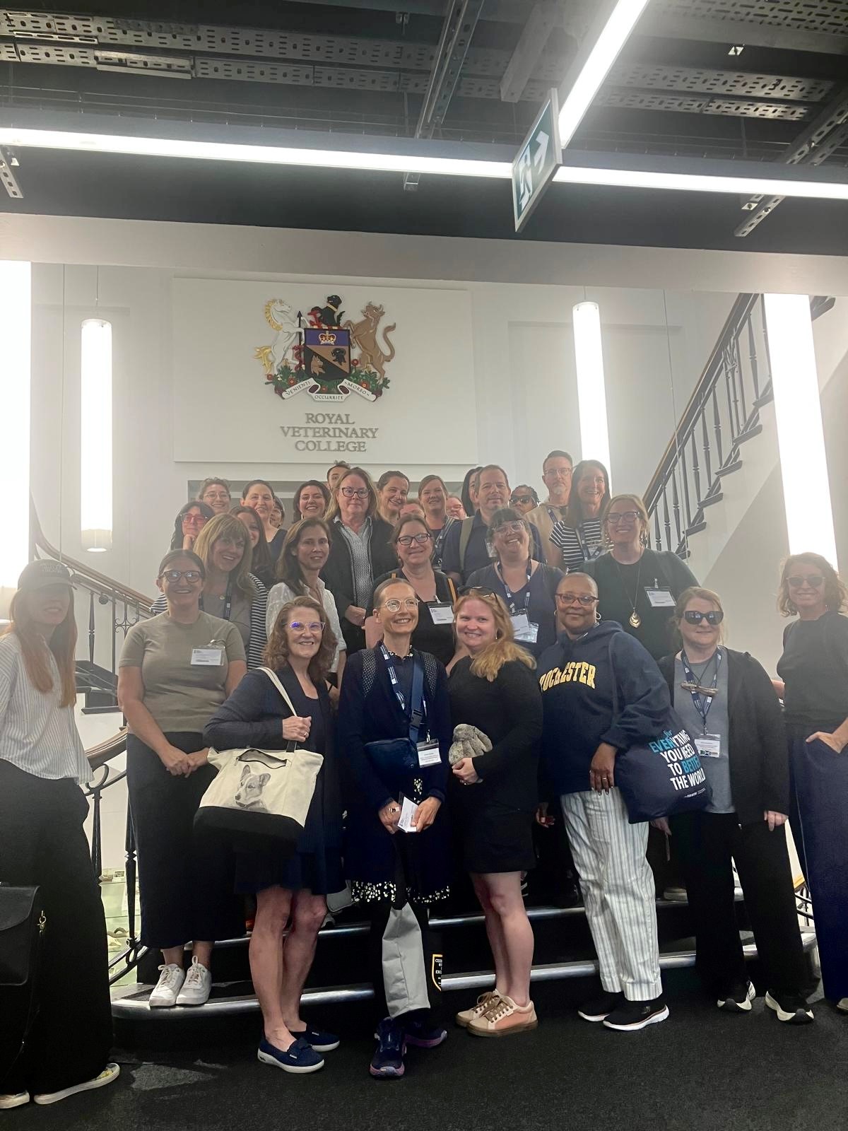Group of 35 NAFAns stand on stairs underneath the Royal Veterinary College crest