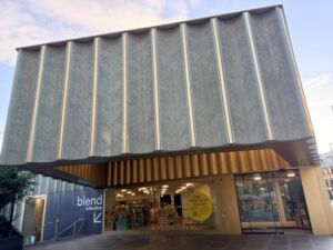 Front entrance of Nottingham Contemporary, a modern art gallery with a striking façade of textured pale-green panels and vertical metal ribs.